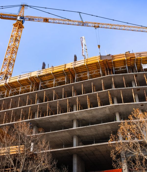 Multi-level concrete building under construction with tower crane; new residential development in the heart of Silicon Valley, San Jose, California